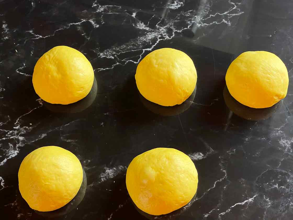 uformowane kulki z ciasta na bułeczki szwedzkie Lussekatter