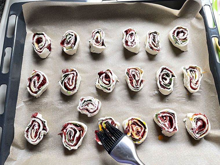 581 / 5.000
Rozgrzej piekarnik do 225°C. Wyłóż blachę papierem do pieczenia. Rozwiń ciasto francuskie. Zetrzyj ser górski na grubej tarce. Doprawić serek śmietankowy solą i pieprzem. Bazylię umyj, osusz, oberwij listki i posiekaj je grubo.

2. Posmaruj ciasto francuskie serkiem śmietankowym, połóż na nie bresaolę, posyp bazylią i startym serem górskim. Zwiń ciasto francuskie zaczynając od dłuższego boku i pokrój na około 24 kawałki. Ułóż ślimaki na blasze do pieczenia. Rozmieszaj żółtko z mlekiem i cienko posmaruj nim ślimaki. Piec w gorącym piekarniku przez około 15 minut. Smakuje zarówno na ciepło, jak i na zimno.